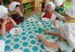 Dzieci kończą zajadać deser i korzystają z serwetek deserowych.